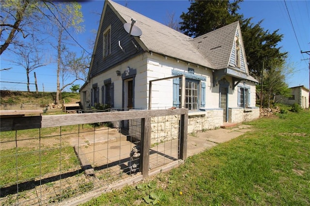 25388 Chieftain Rd, Lawrence, KS 66044 - view of property exterior featuring fence, a lawn, and roof with shingles