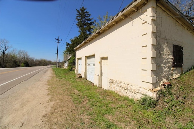 25388 Chieftain Rd, Lawrence, KS 66044 - view of side of property featuring a garage and concrete block siding