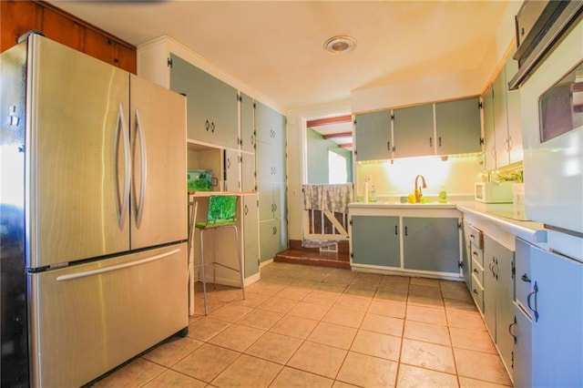 25388 Chieftain Rd, Lawrence, KS 66044 - kitchen featuring light tile patterned floors, a sink, light countertops, freestanding refrigerator, and green cabinets