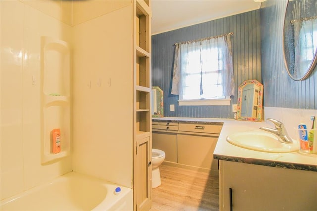25388 Chieftain Rd, Lawrence, KS 66044 - bathroom with toilet, vanity, wood finished floors, wallpapered walls, and shower / tub combination