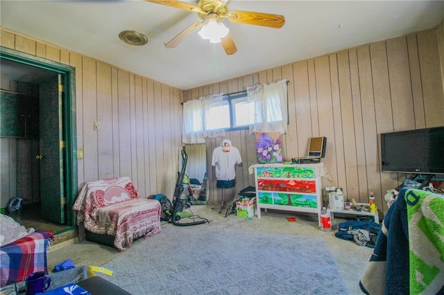 25388 Chieftain Rd, Lawrence, KS 66044 - game room with wood walls, a ceiling fan, and carpet floors