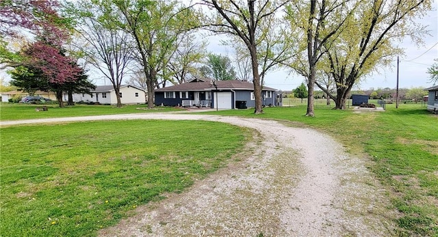 1463 Missouri Rd, Iola, KS 66749 - ranch-style home with curved driveway, a front yard, and a garage