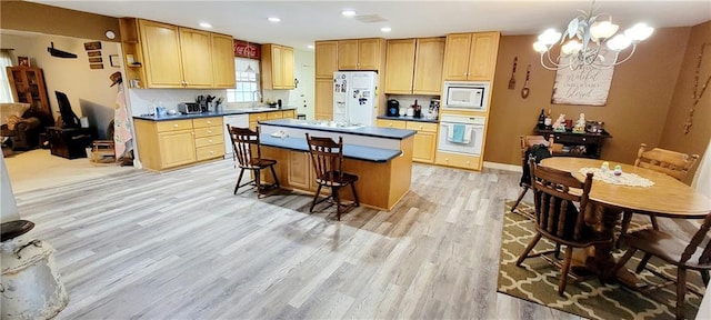 1463 Missouri Rd, Iola, KS 66749 - kitchen featuring white appliances, a chandelier, light wood-style flooring, a center island, and dark countertops