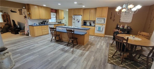 1463 Missouri Rd, Iola, KS 66749 - kitchen featuring white appliances, a chandelier, light wood-type flooring, dark countertops, and a kitchen island