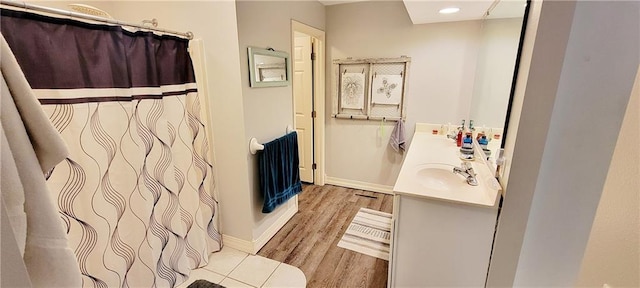 1463 Missouri Rd, Iola, KS 66749 - bathroom with wood finished floors, double vanity, baseboards, recessed lighting, and a shower with shower curtain