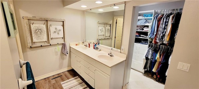1463 Missouri Rd, Iola, KS 66749 - full bath featuring a walk in closet, double vanity, wood finished floors, recessed lighting, and baseboards