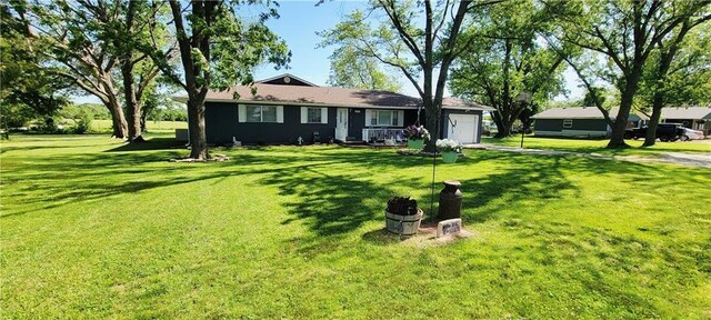 1463 Missouri Rd, Iola, KS 66749 - ranch-style house with an attached garage, driveway, and a front lawn