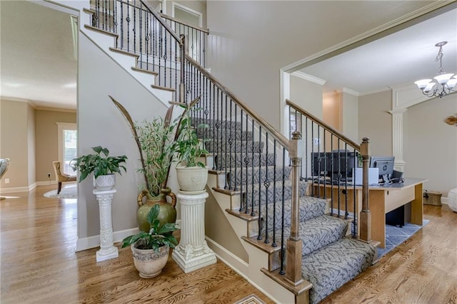 4102 NW 76th Ter, Kansas City, MO 64151 - stairway featuring wood finished floors, crown molding, baseboards, and a chandelier