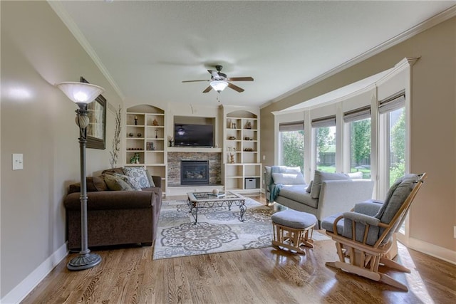 4102 NW 76th Ter, Kansas City, MO 64151 - living area featuring baseboards, a ceiling fan, crown molding, a glass covered fireplace, and wood finished floors