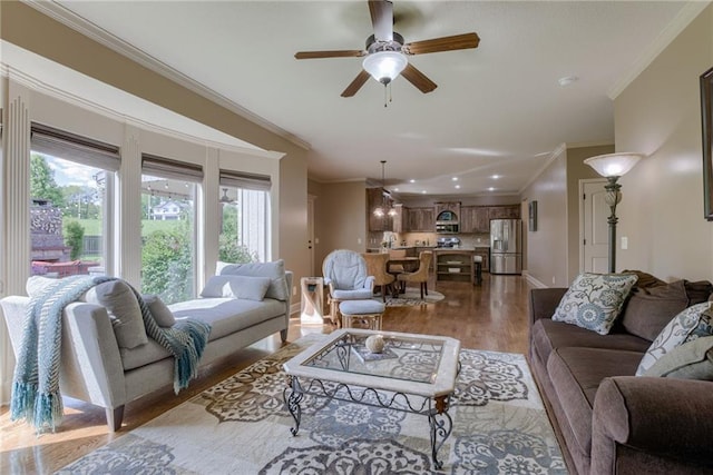 4102 NW 76th Ter, Kansas City, MO 64151 - living area featuring wood finished floors, ornamental molding, ceiling fan, recessed lighting, and baseboards