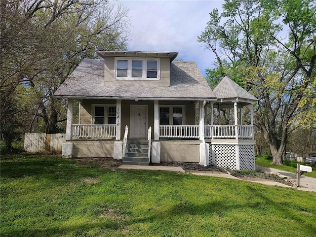 10816 E 27th St, Independence, MO 64052 - view of front of home featuring a porch, fence, roof with shingles, and a front yard