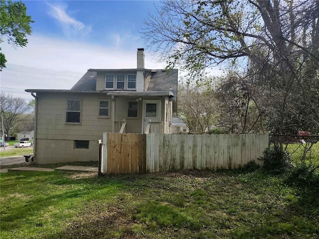 10816 E 27th St, Independence, MO 64052 - back of house featuring fence, a chimney, and a yard