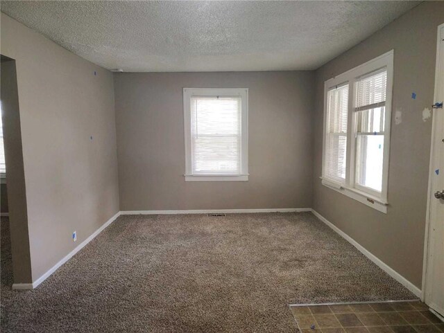 10816 E 27th St, Independence, MO 64052 - unfurnished room with plenty of natural light, dark colored carpet, and a textured ceiling