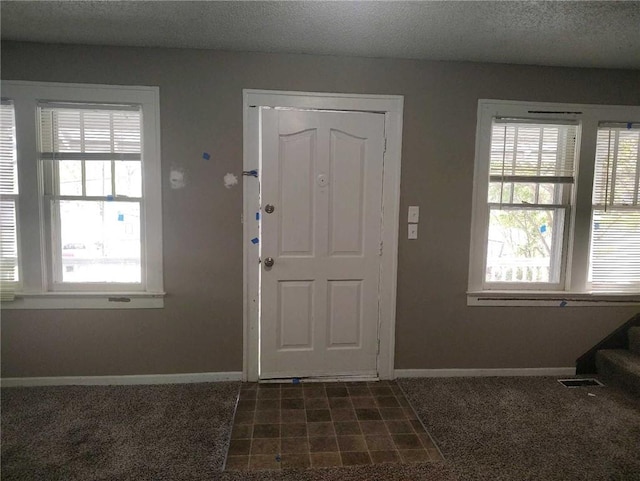 10816 E 27th St, Independence, MO 64052 - entryway with stairway, a textured ceiling, baseboards, dark colored carpet, and visible vents