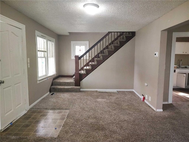 10816 E 27th St, Independence, MO 64052 - entrance foyer with stairway, a textured ceiling, carpet flooring, and baseboards