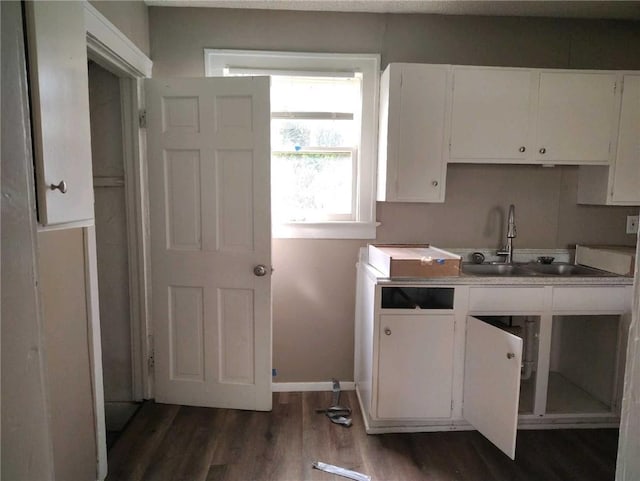 10816 E 27th St, Independence, MO 64052 - kitchen featuring dark wood finished floors, baseboards, a sink, and white cabinets