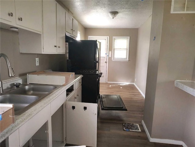 10816 E 27th St, Independence, MO 64052 - kitchen featuring light wood finished floors, baseboards, visible vents, and white cabinets