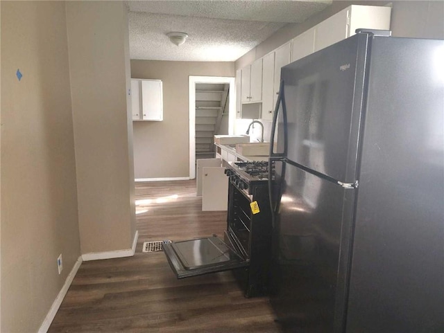 10816 E 27th St, Independence, MO 64052 - kitchen featuring a sink, wood finished floors, baseboards, white cabinetry, and freestanding refrigerator