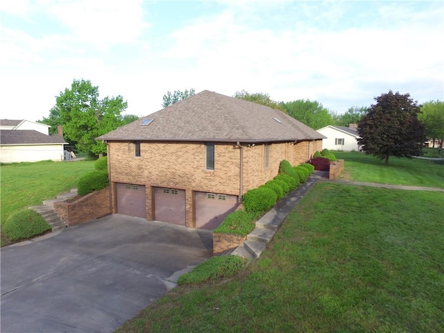 1410 Grandview Dr, Warrensburg, MO 64093 - view of side of property featuring an attached garage, concrete driveway, a lawn, and brick siding
