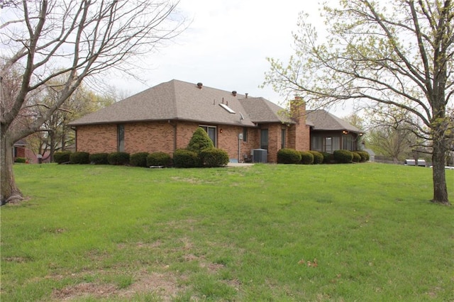 1410 Grandview Dr, Warrensburg, MO 64093 - view of side of property with central AC unit, a lawn, a chimney, and brick siding