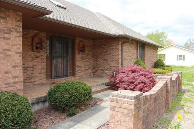 1410 Grandview Dr, Warrensburg, MO 64093 - entrance to property featuring brick siding, covered porch, and roof with shingles
