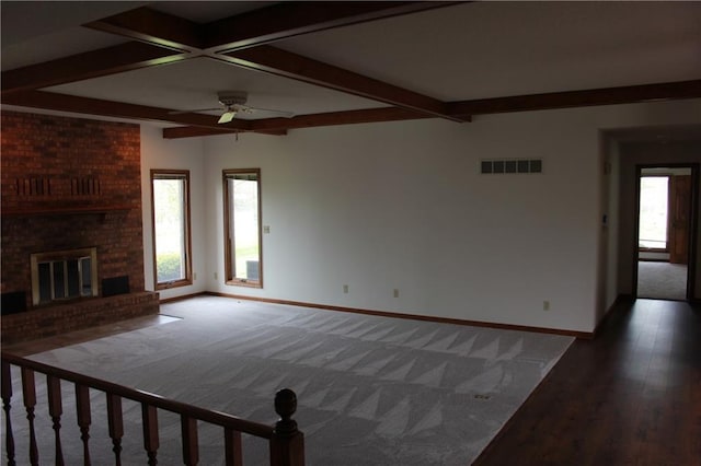 1410 Grandview Dr, Warrensburg, MO 64093 - unfurnished living room featuring baseboards, beamed ceiling, ceiling fan, carpet floors, and a fireplace
