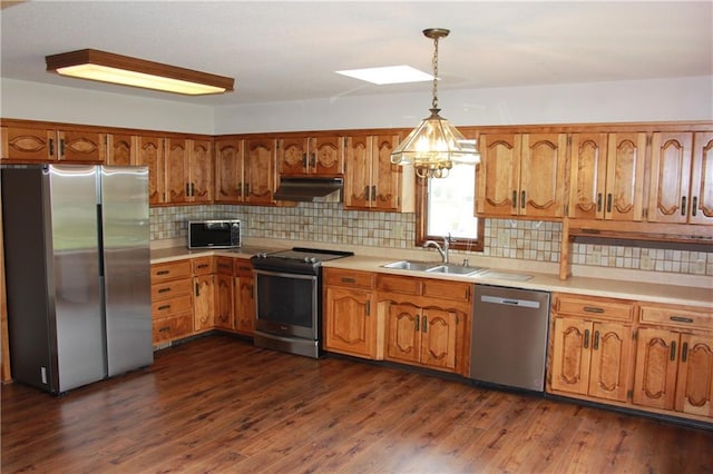 1410 Grandview Dr, Warrensburg, MO 64093 - kitchen featuring stainless steel appliances, a sink, under cabinet range hood, and brown cabinetry