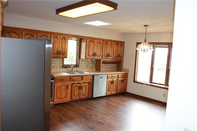 1410 Grandview Dr, Warrensburg, MO 64093 - kitchen with appliances with stainless steel finishes, a sink, brown cabinets, light countertops, and decorative backsplash