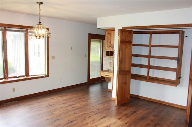 1410 Grandview Dr, Warrensburg, MO 64093 - spare room featuring dark wood-style floors, a chandelier, and baseboards