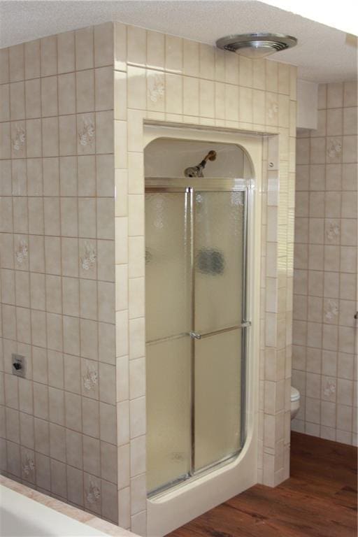 1410 Grandview Dr, Warrensburg, MO 64093 - bathroom with a shower with shower door, wood finished floors, and toilet