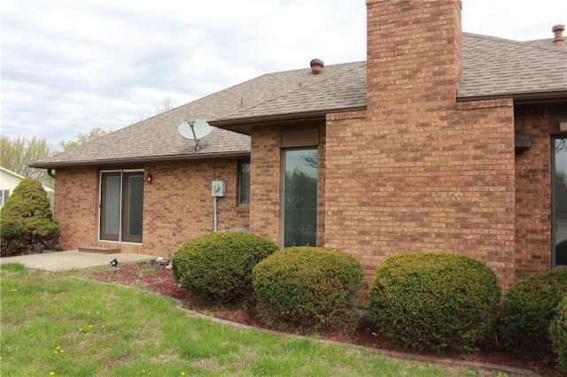 1410 Grandview Dr, Warrensburg, MO 64093 - view of side of property featuring roof with shingles, a chimney, and brick siding