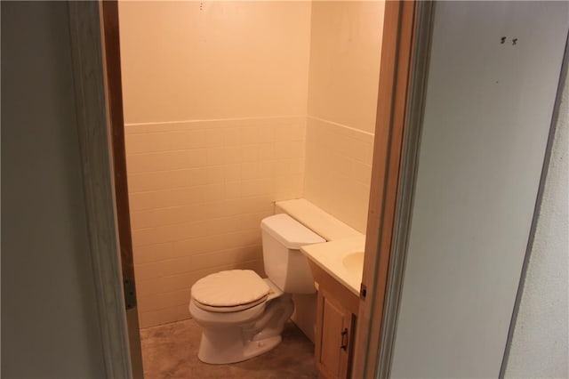 1410 Grandview Dr, Warrensburg, MO 64093 - half bath featuring toilet, vanity, wainscoting, and tile walls