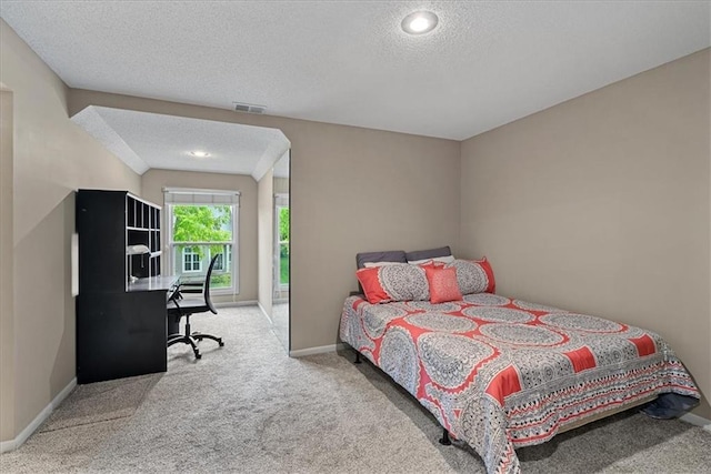 carpeted bedroom with a textured ceiling, baseboards, and an office area