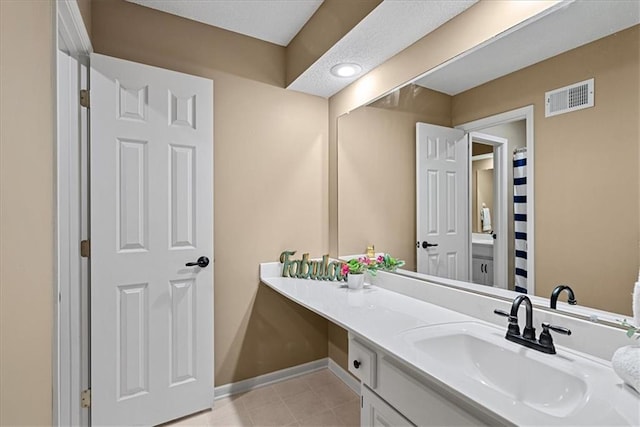 full bathroom with vanity, tile patterned floors, and baseboards