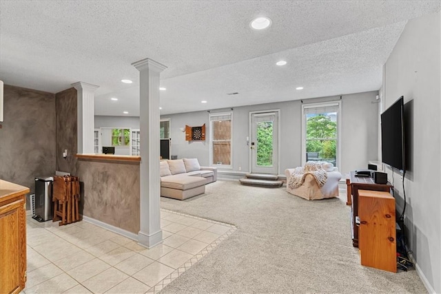 living area with ornate columns, a textured ceiling, light colored carpet, recessed lighting, and baseboards