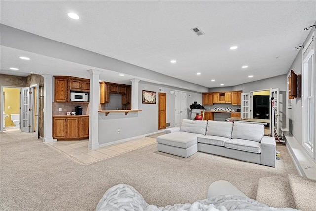 living area with light colored carpet, recessed lighting, baseboards, and ornate columns