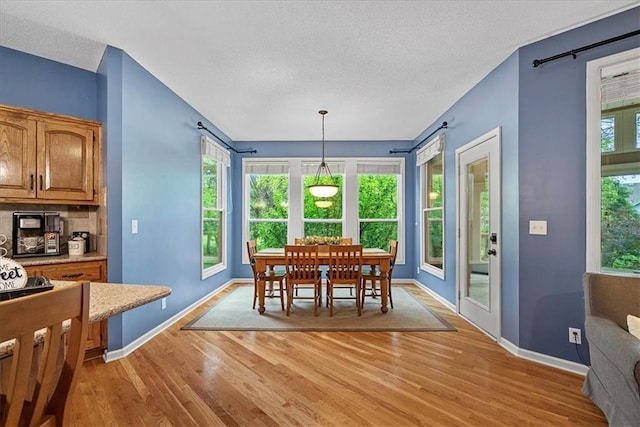 14124 Flint St, Overland Park, KS 66221 - dining room with light wood-style flooring, a textured ceiling, baseboards, and plenty of natural light