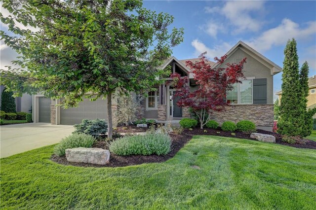 view of front of home with driveway, stucco siding, a front yard, and stone siding