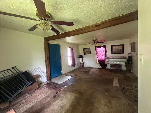 218 S Kent St, Excelsior Springs, MO 64024 - unfurnished living room featuring ceiling fan and a textured ceiling