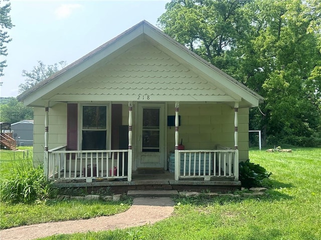 218 S Kent St, Excelsior Springs, MO 64024 - bungalow-style house featuring covered porch and a front lawn