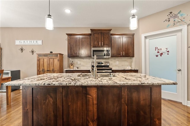 19625 E 18th Ter, Independence, MO 64057 - kitchen with appliances with stainless steel finishes, a sink, light wood-style floors, backsplash, and dark brown cabinetry