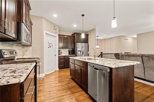 19625 E 18th Ter, Independence, MO 64057 - kitchen with stainless steel appliances, dark brown cabinets, light wood-style floors, open floor plan, and tasteful backsplash