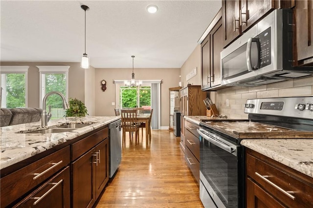19625 E 18th Ter, Independence, MO 64057 - kitchen with stainless steel appliances, a sink, light wood-type flooring, decorative light fixtures, and dark brown cabinets