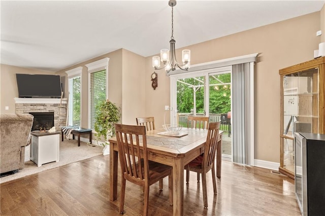 19625 E 18th Ter, Independence, MO 64057 - dining space with wood finished floors, a chandelier, a fireplace, and baseboards