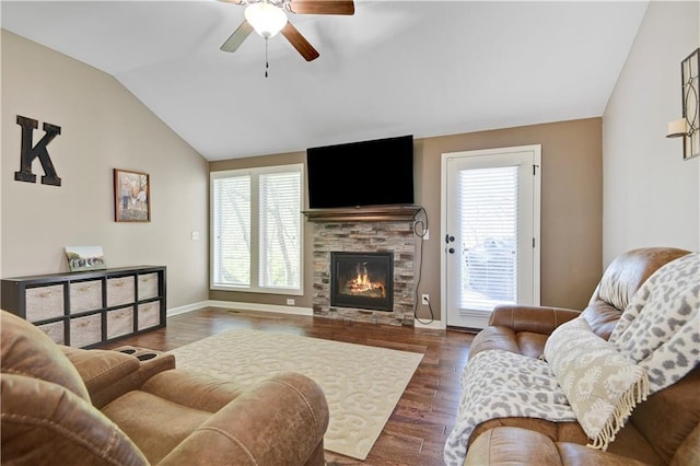 living area featuring ceiling fan, lofted ceiling, a fireplace, and a wealth of natural light