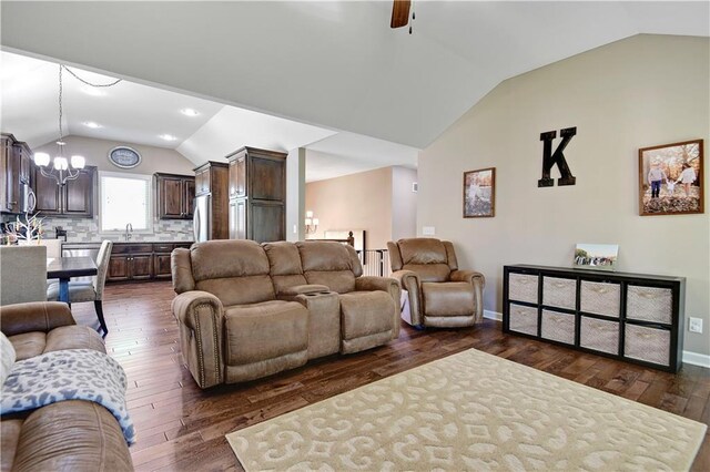living room featuring recessed lighting, dark wood-style floors, vaulted ceiling, baseboards, and ceiling fan with notable chandelier