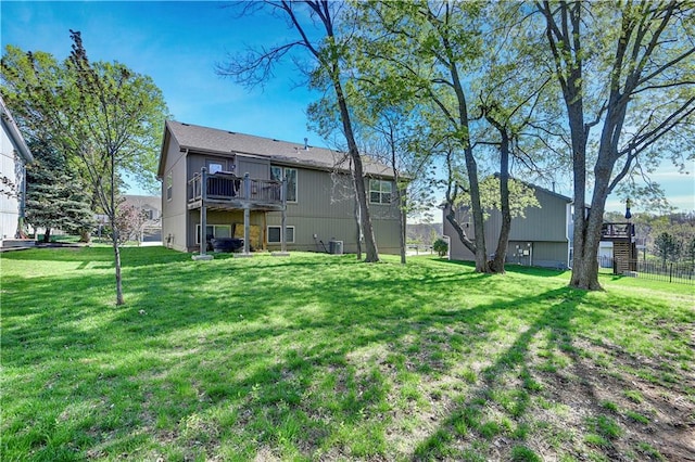 back of house with fence, a yard, and a deck