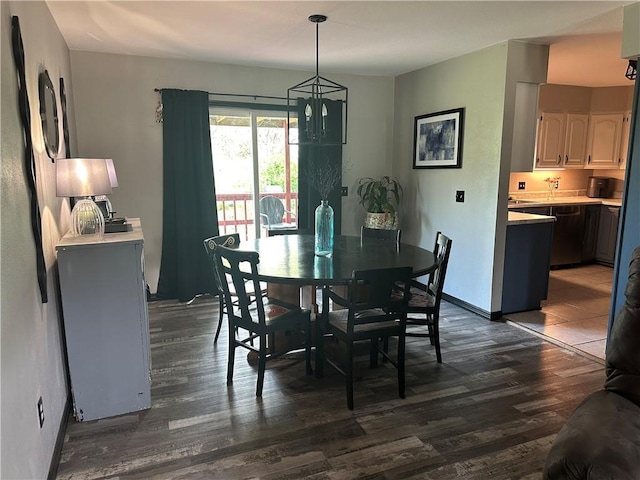 dining area featuring baseboards, a chandelier, and dark wood-style floors