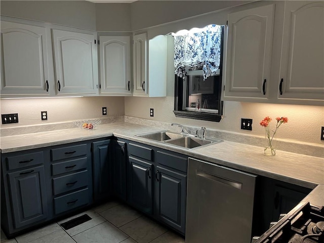 kitchen with light countertops, light tile patterned flooring, a sink, and white cabinetry