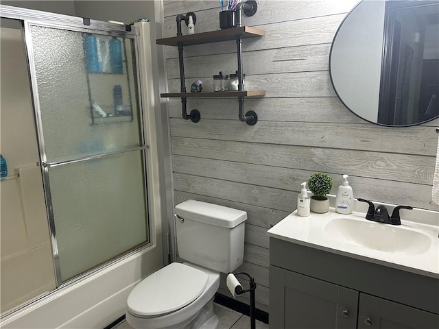 full bath featuring toilet, wood walls, and vanity